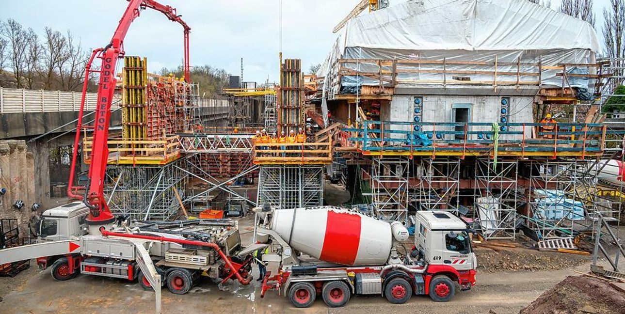 Im Vordergrund wird das noch fehlende Widerlager gebaut, während sich unter dem Zelt die künftige Brücke befindet.