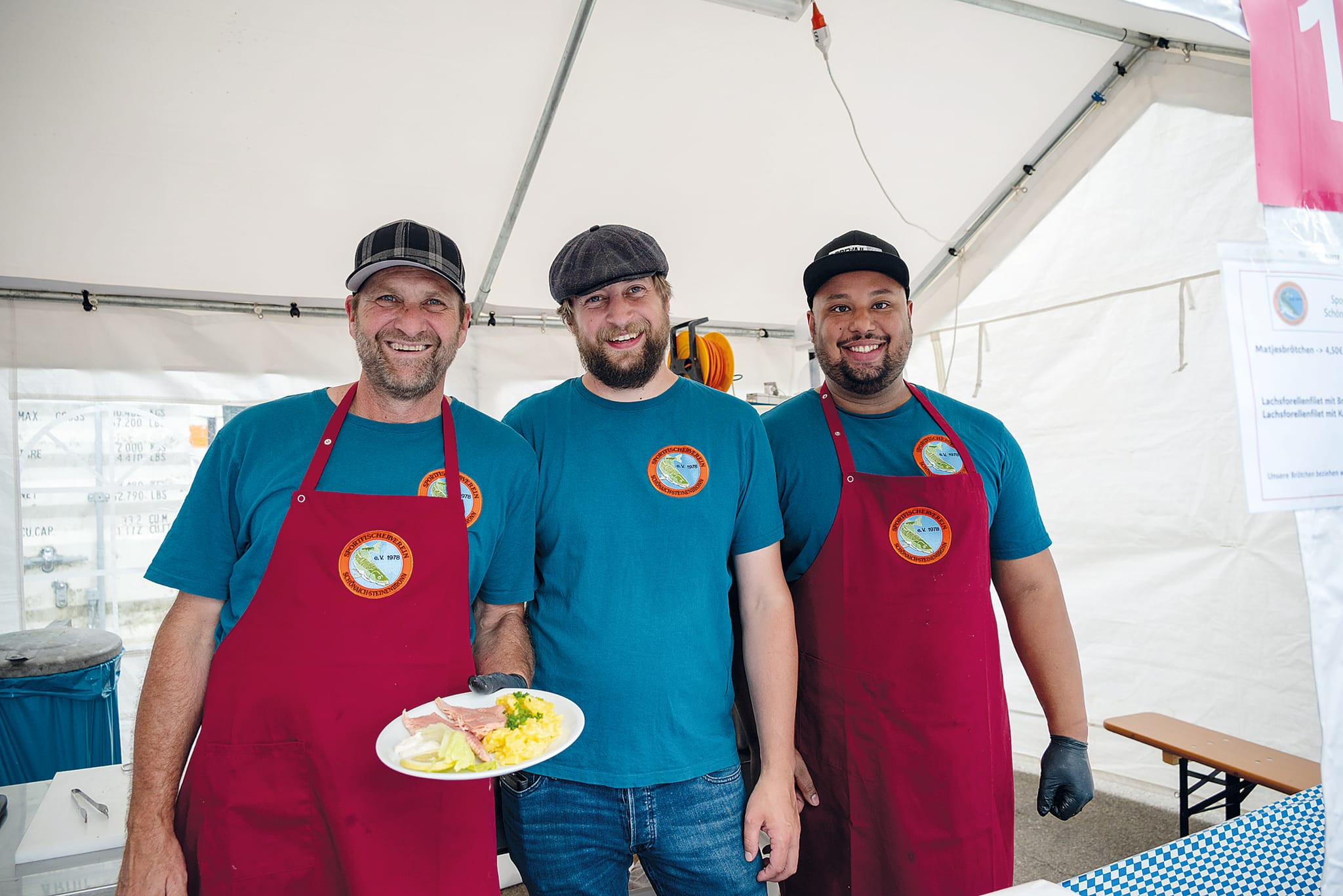 Frisch aus dem Teich, die Sportfischer Max Post, Michael Schroeter und Dennis Jawo servieren Lachsforelle mit Kartoffelsalat. Bild: Nüßle