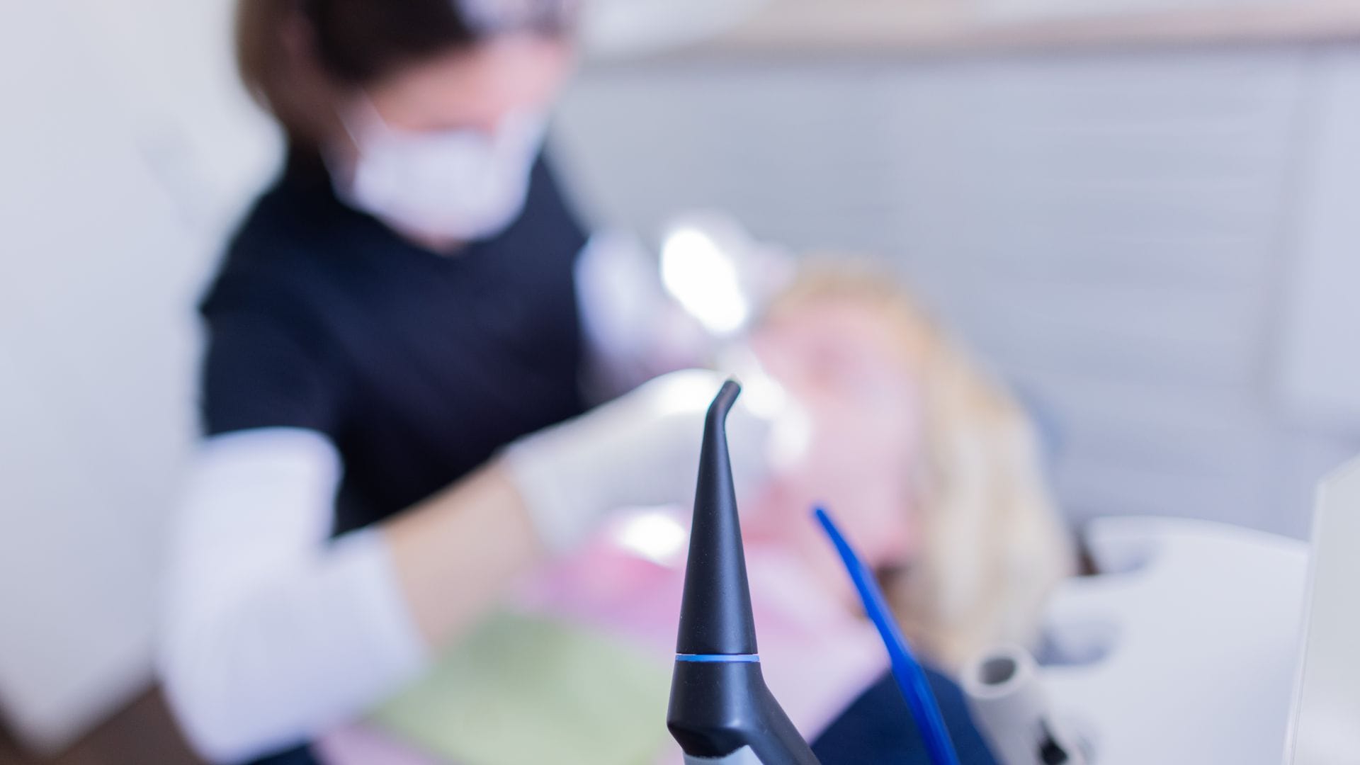 Eine Zahnarzthelferin führt an einer Patientin eine Zahnreinigung durch.