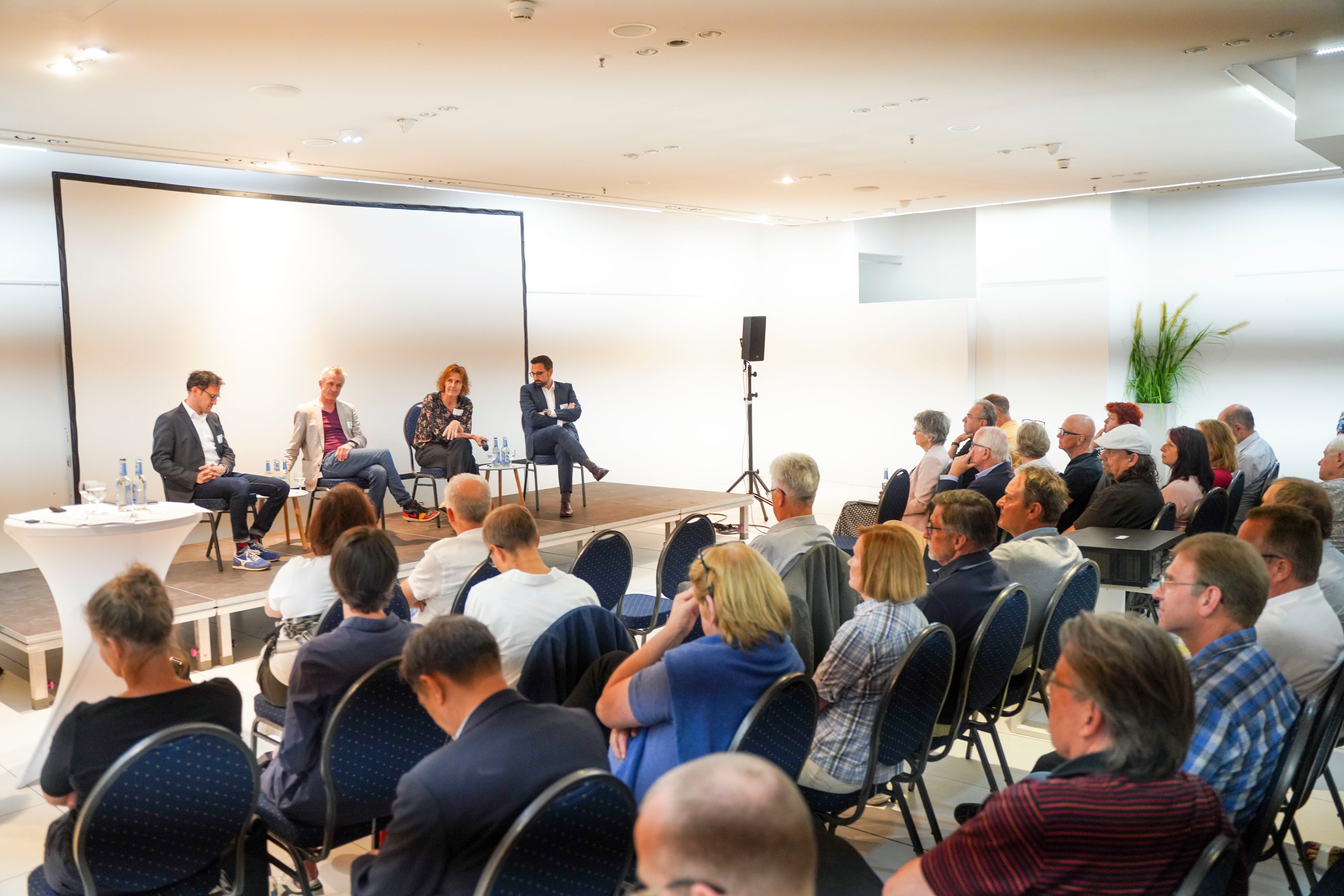 Die Besucher hören genau zu, was Stadtentwickler Michael Paak, IBA-Intendant Andreas Hofer, Baubürgermeisterin Dr. Corinna Clemens und Verkehrsplaner Dr. Markus Wiese zu sagen haben (von links).      Bild: Dettenmeyer
