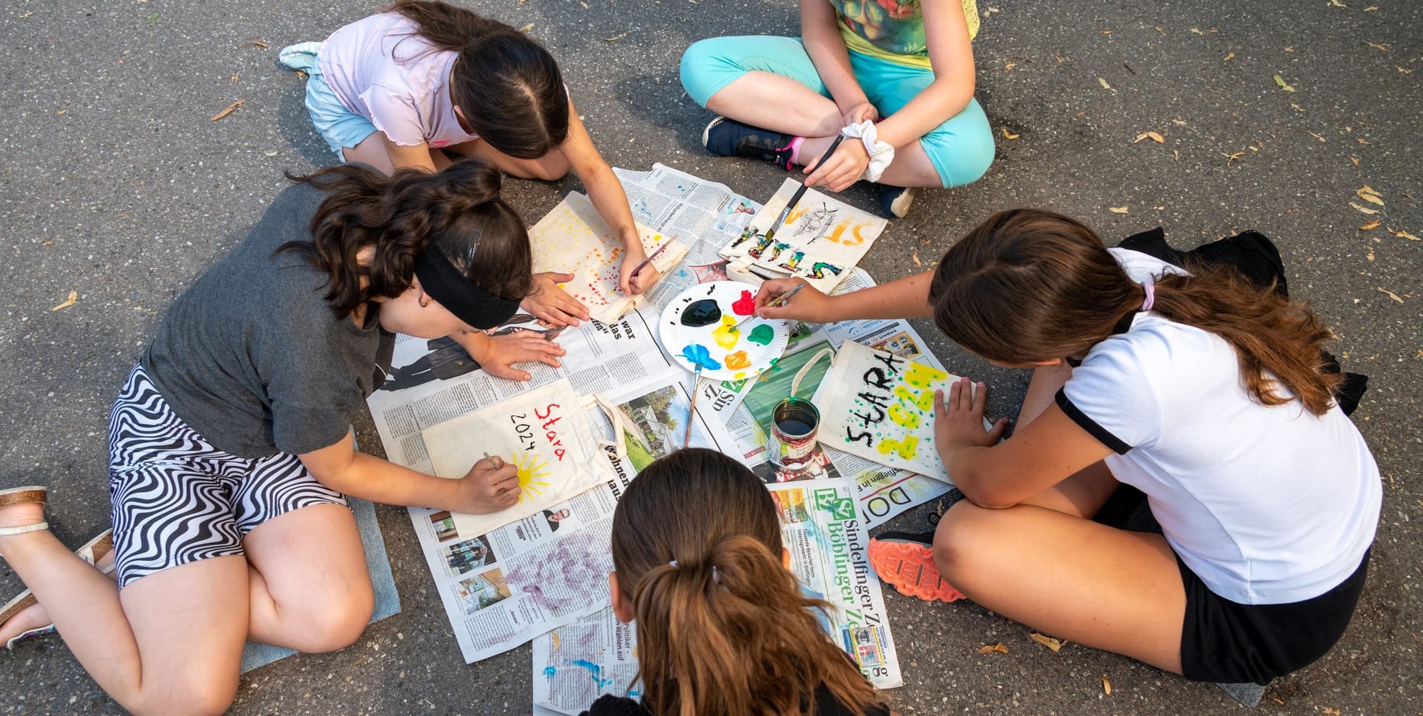 Taschen bemalen  wird bei schönem Wetter nach draußen verlegt. Bild: Nüßle