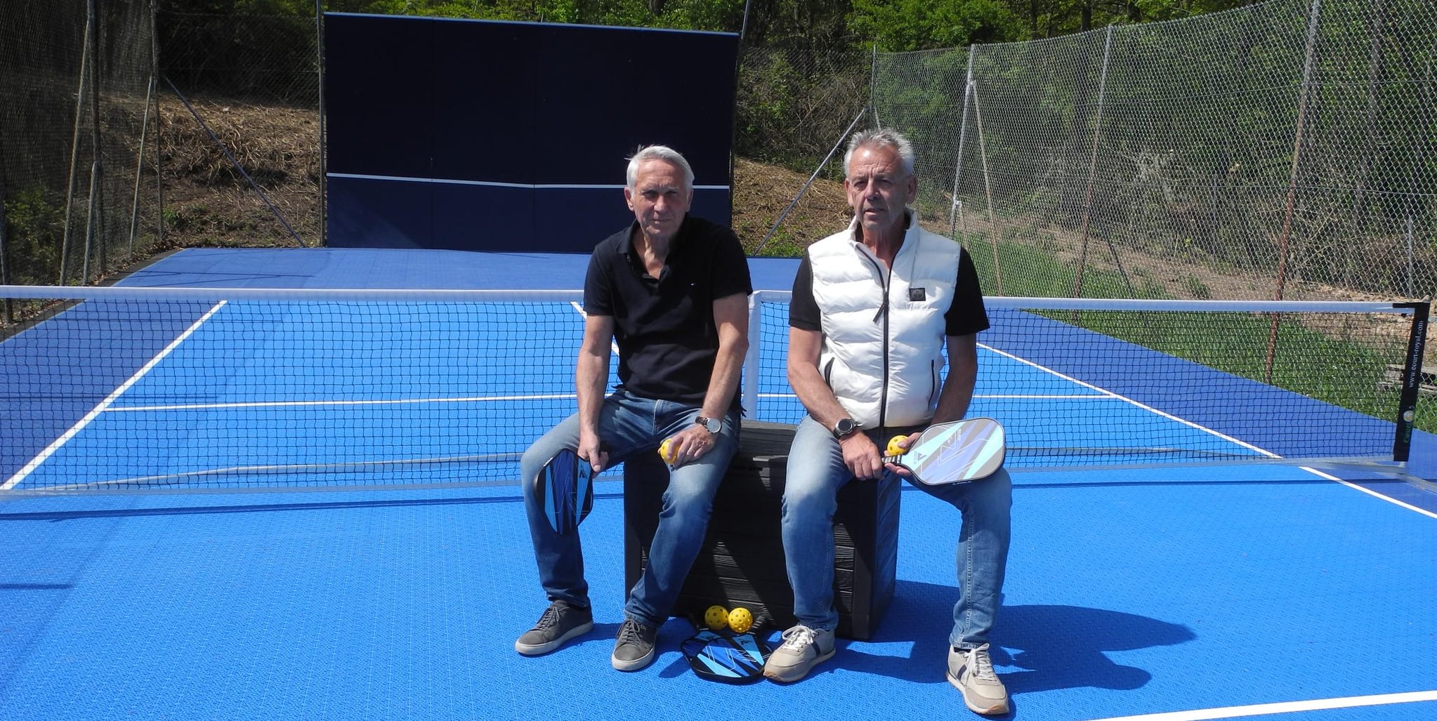 Hans Schumacher (links) und Norbert Burger, Vorsitzender beziehungsweise Technischer Vorstand beim TC Schönaich, auf dem neu errichteten Pickleballplatz, im Hintergrund die neu gestrichene Ballwand.