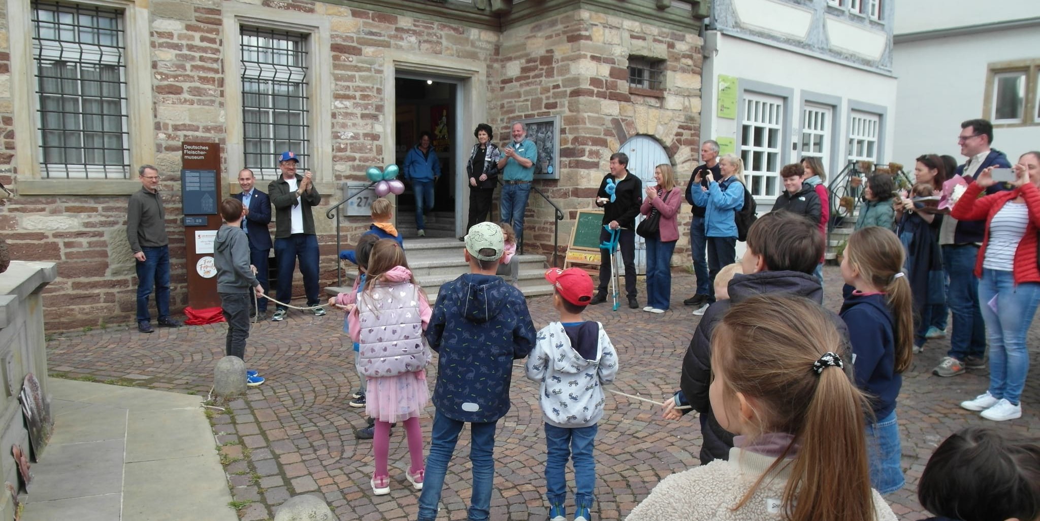 Gemeinsam mit zahlreichen Kindern haben Bodo Ulrich vom Verband kinderreicher Familien Deutschland, Böblingens Oberbürgermeister Dr. Stefan Belz und Dr. Christian Baudisch (von links) am Kindermuseumssonntag die Plakette mit dem „Fair Family“-Siegel des F