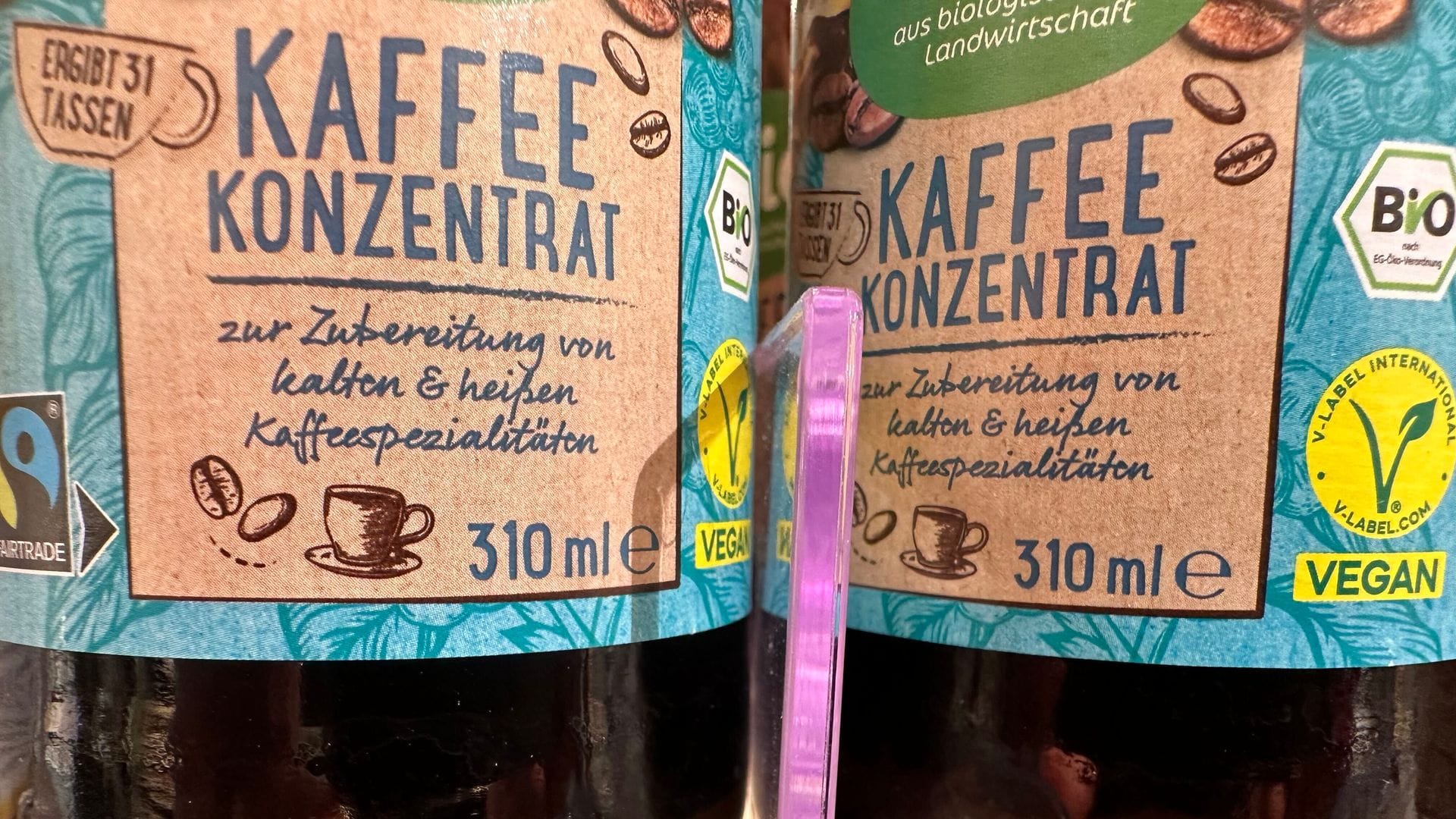 Flaschen mit Kaffeekonzentrat stehen in einem Drogeriemarktregal. (Archivbild)