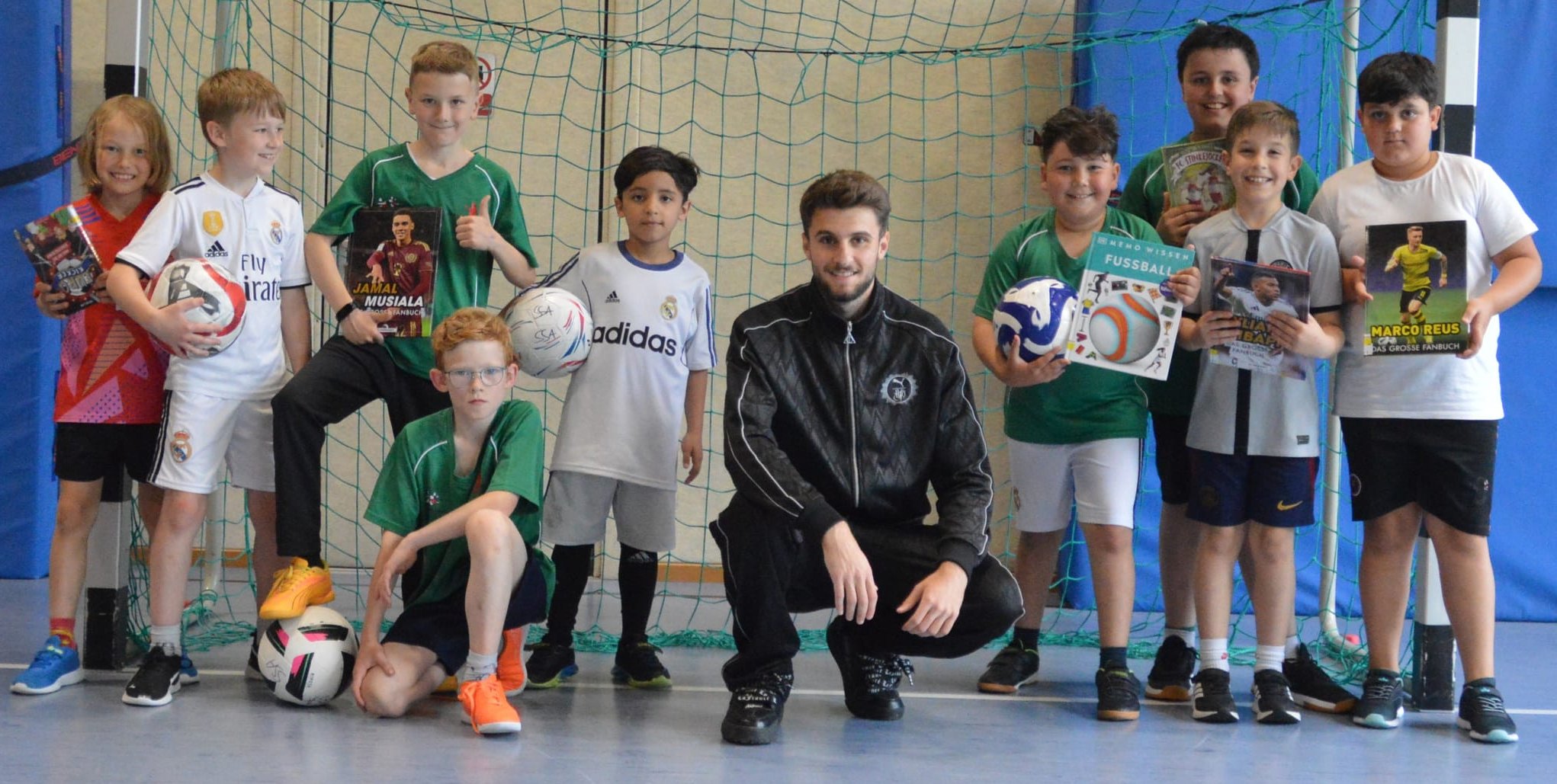 VfB-Nachwuchsstar Eliot Bujupi und die Schüler der Sindelfinger Klostergartenschule spielen beim Projekt „kicken & lesen“ eine Art literarischen Doppelpass.