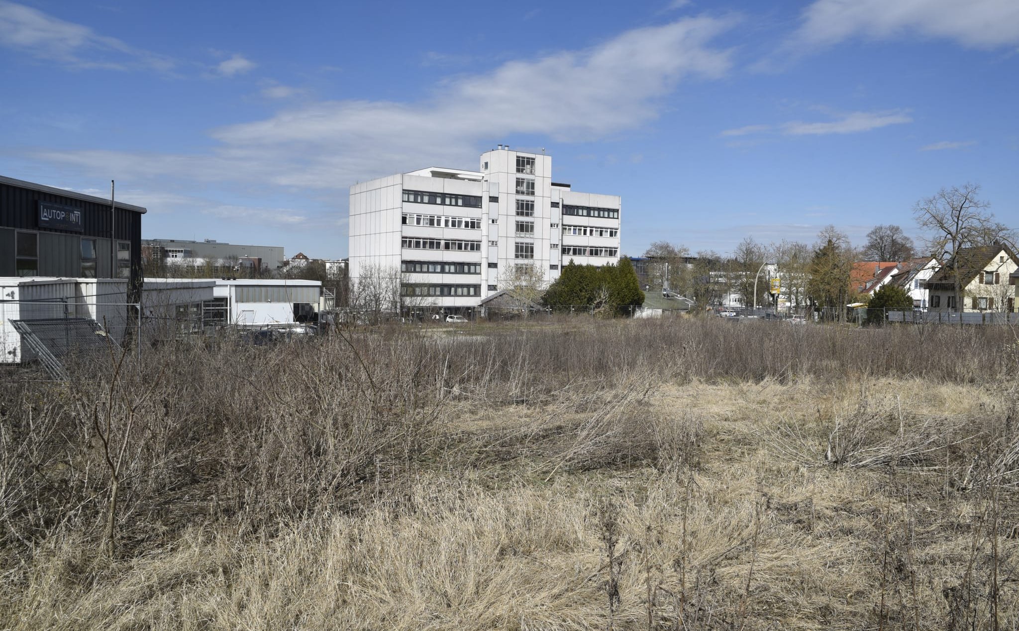 Der Blick von Norden (Carl-Zeiss-Straße) auf das verwilderte Baugrundstück. Rechts auf der anderen Seite der Böblinger Straße die unteren Einfamilienhäuser der Goldberg-Siedlung.