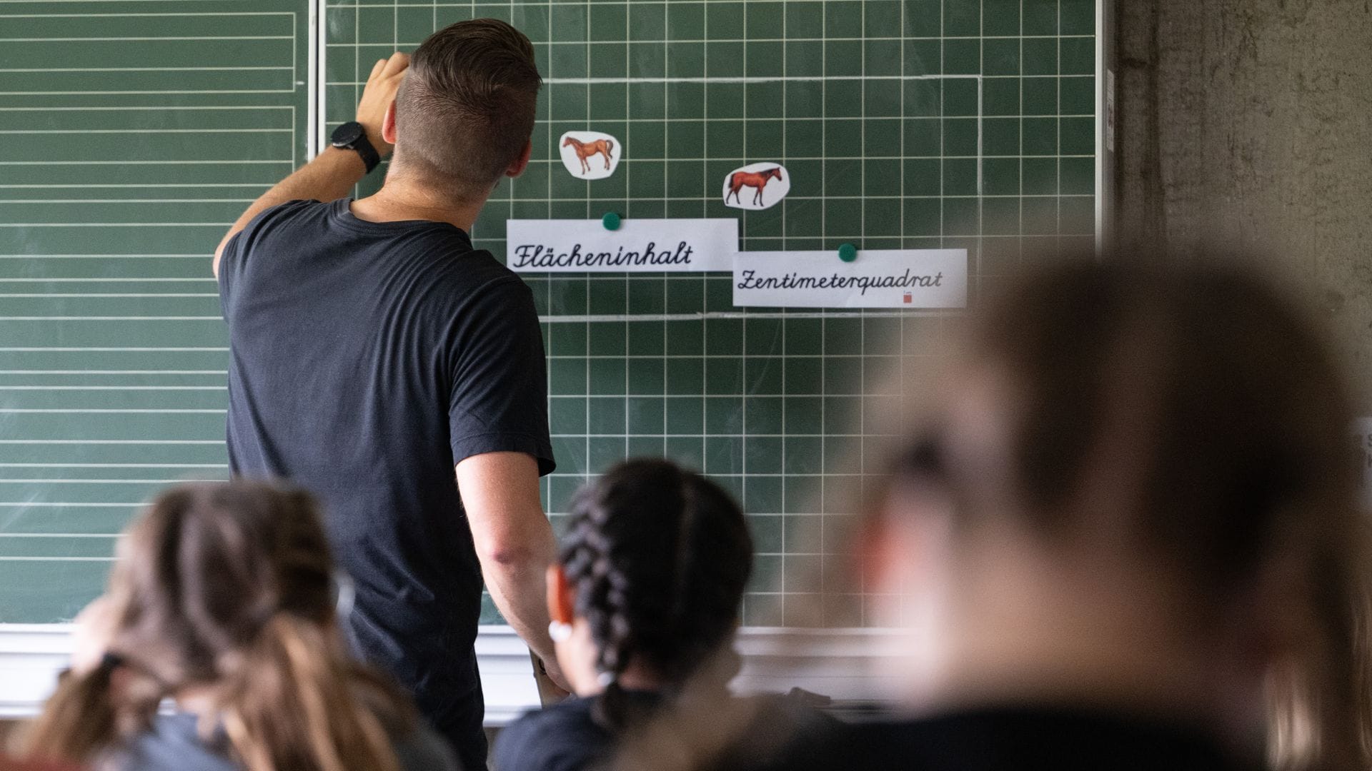 Ein Mathelehrer will seiner Klasse die Berechnung von Flächen erklären.