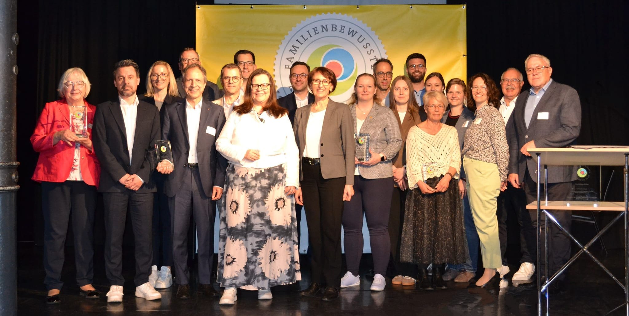 Unser Foto zeigt die ausgezeichneten Prädikatskommunen der Jahre 23/24 gemeinsam mit Staatssekretärin Dr. Ute Leidig (Mitte: grauer Blazer, helles Oberteil, dunkle Hose).