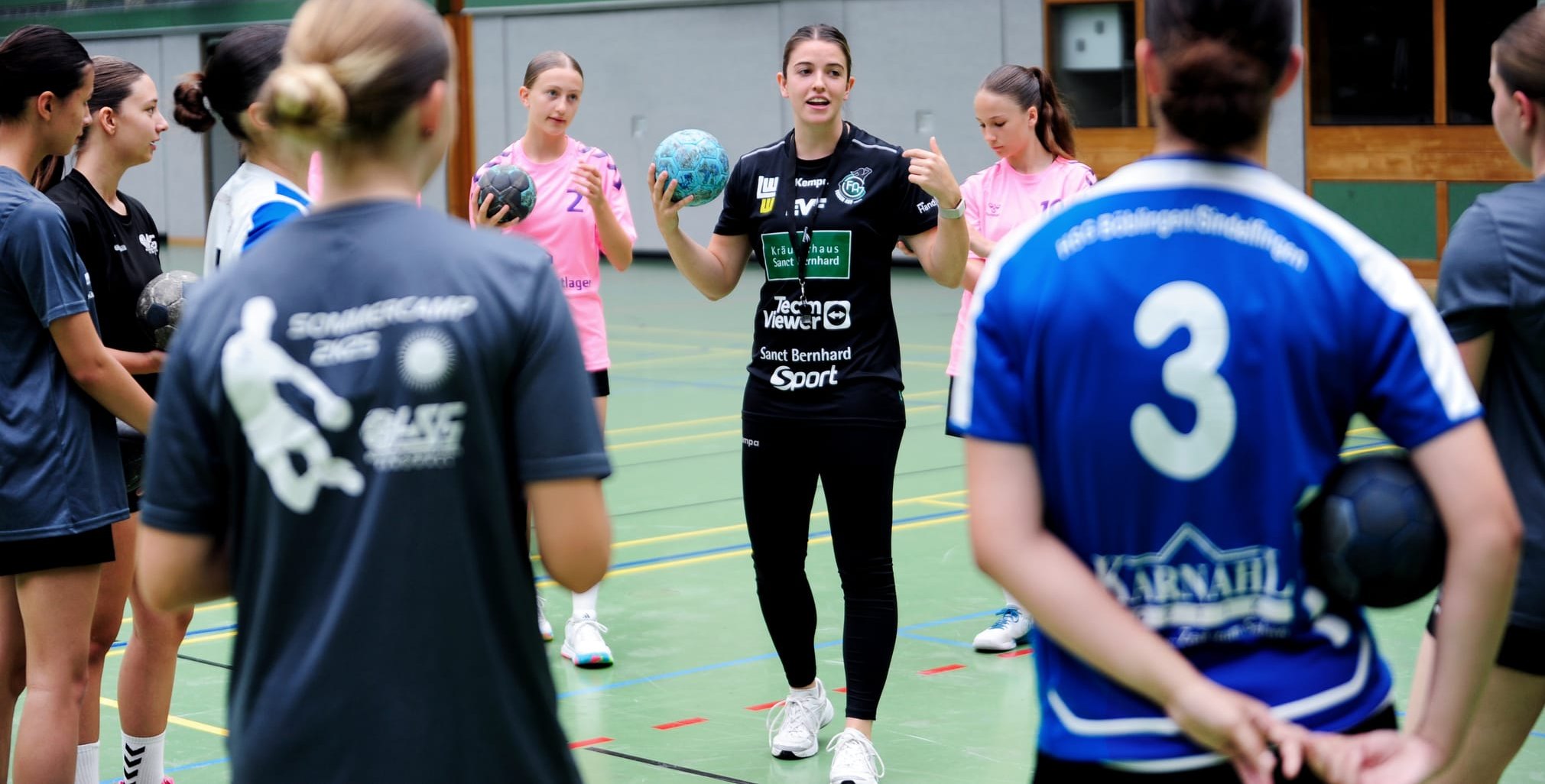 Lea Neubrander  (schwarzes Trikot) im Gespräch mit den Nachwuchs-Handballerinnen der HSG Böblingen/Sindelfingen. Bild: photostampe
