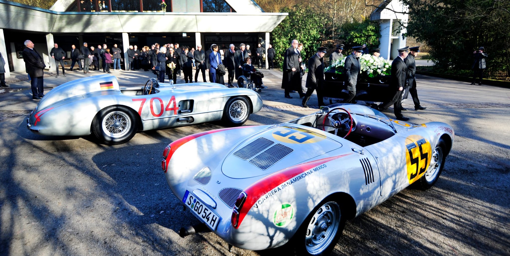 Hans Herrmanns letzter Weg vobei an zwei seiner legendären Rennwagen, einem Mercedes „Silberpfeil“ 300 SLR und ein Porsche 550. 	Bild: Photostampe