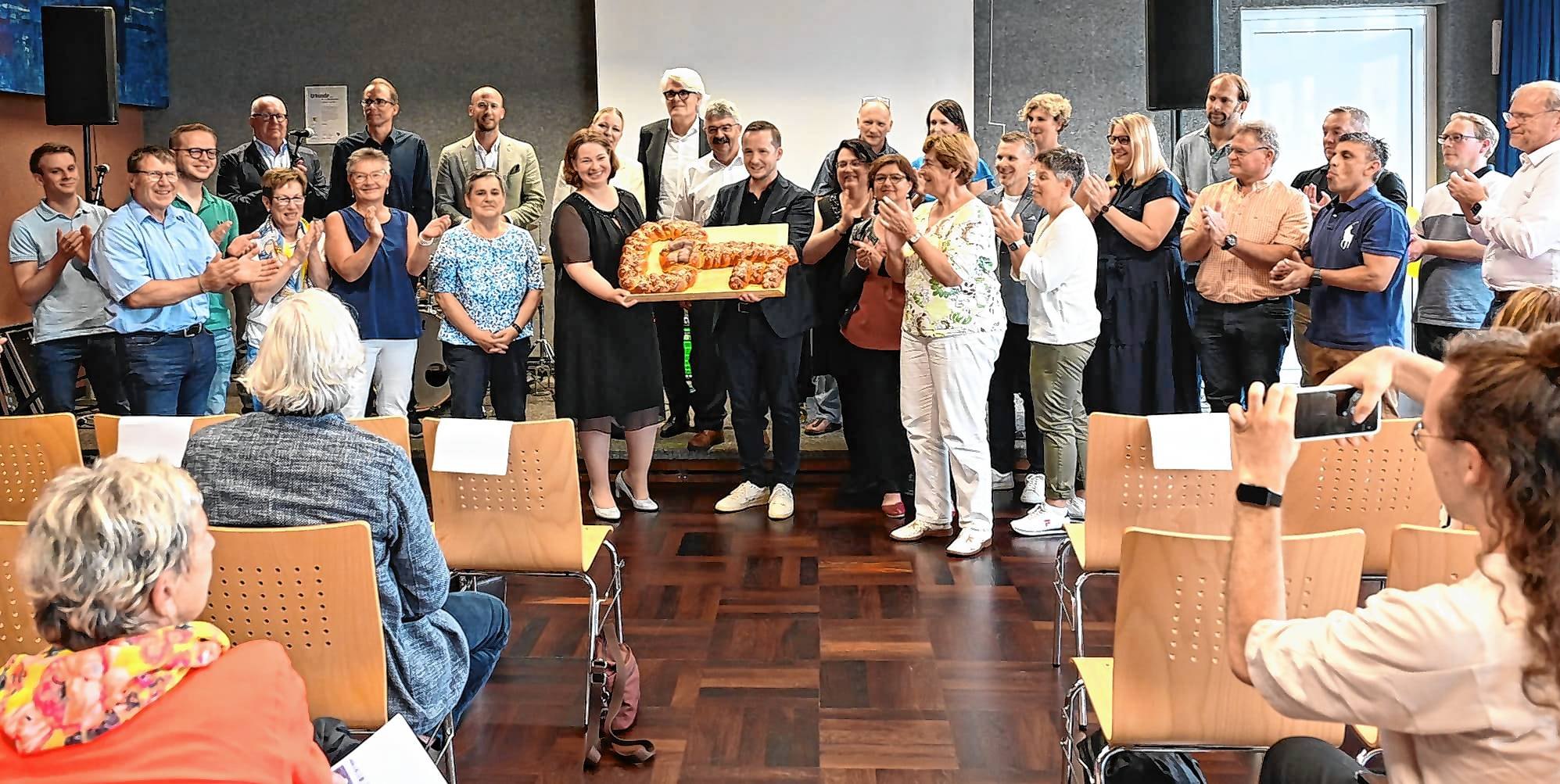 Beifall für die neuen Schulräume gab‘s beim Festakt von alten wie auch von frisch gewählten Gemeinderäten, Architekten und Vertreterinnen der Schule. Den Hefezopf-Schlüssel halten Schulleiterin Heike Wizemann und Bürgermeister Florian Glock.
