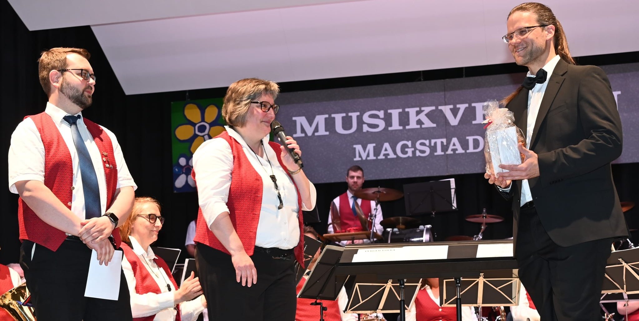 Die „Neuen“ beim Musikverein Magstadt: Christiane Dirr (am Mikrofon) und Bastian Prescher (links), die sich den Vereinsvorsitz teilen, bedanken sich bei Dirigent Mathias Broghammer (rechts) für das erste Konzert unter seiner Leitung. Bild: Reichert