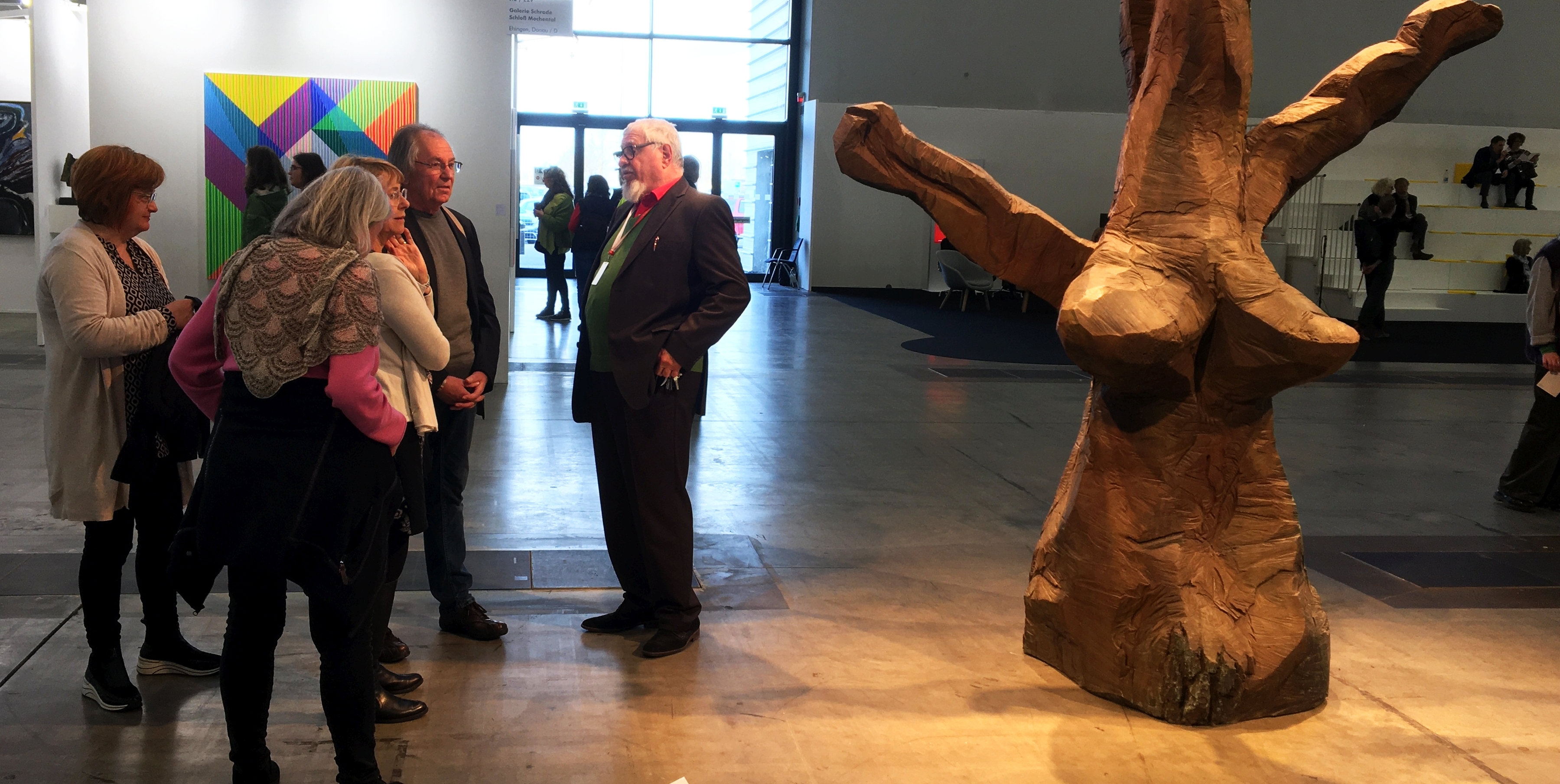 Ewald Karl Schrade (Bildmitte), der Begründer der Art Karlsruhe im Jahr 2004, präsentiert unter der neuen Leitung der Kunstmesse einer Besuchergruppe Skulpturen von Dietrich Klinge in den Hallen von Rheinstetten.
