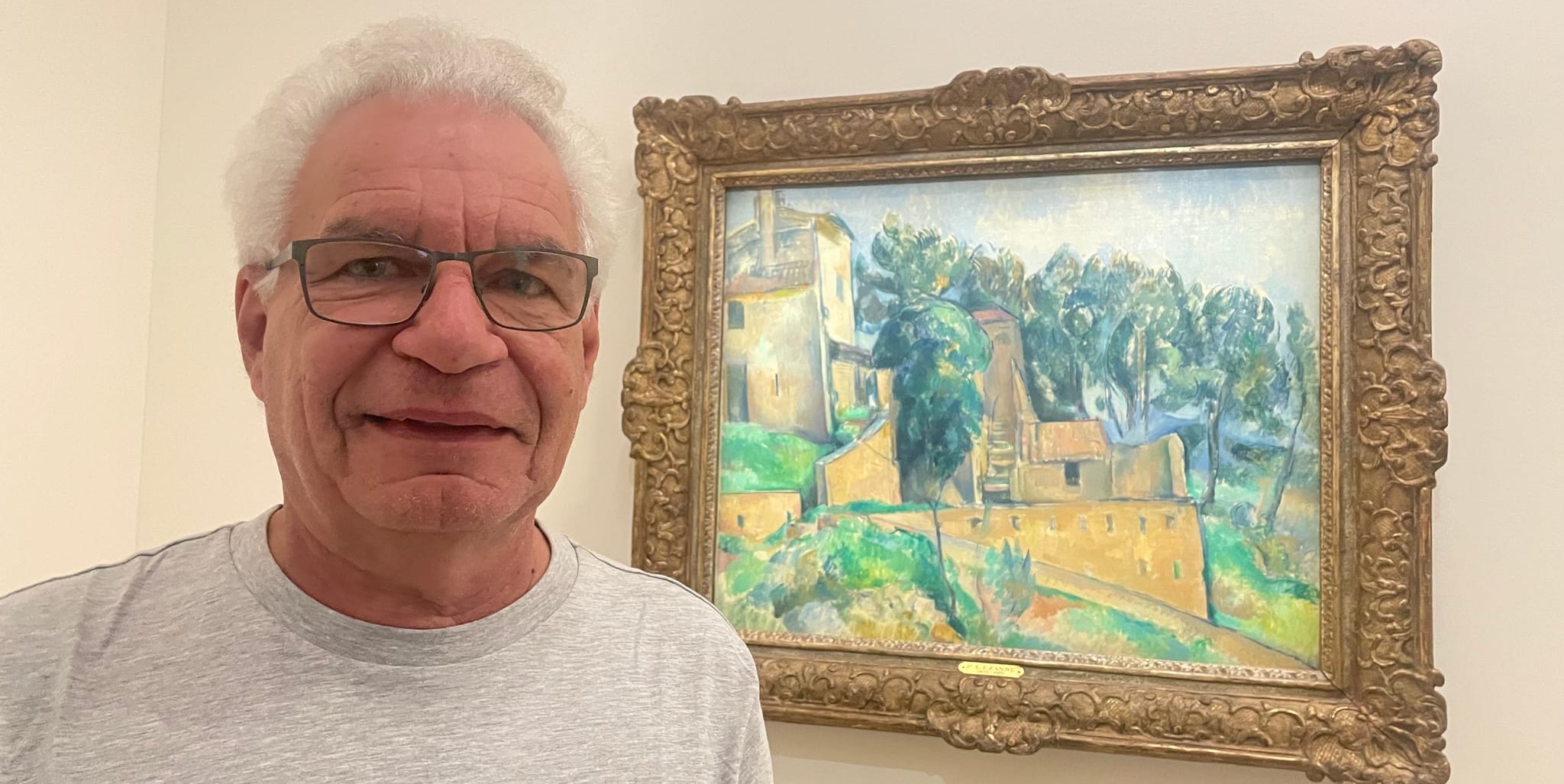 Peter Bausch, über Jahrzehnte hinweg in der SZ/BZ-Redaktion tätig, 2025 in Aix vor dem Gemälde von Paul Cezanne des Hauses, in dem er 17 Jahre lang seine feste Adresse in Südfrankreich hatte.