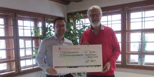 Carsten Vögele (links), Finanzvorstand beim Weissen Ballett, übergibt  den Scheck über 40 000 Euro an Reinhardt Steinhübl vom Kinderschutzbund. Bild: z