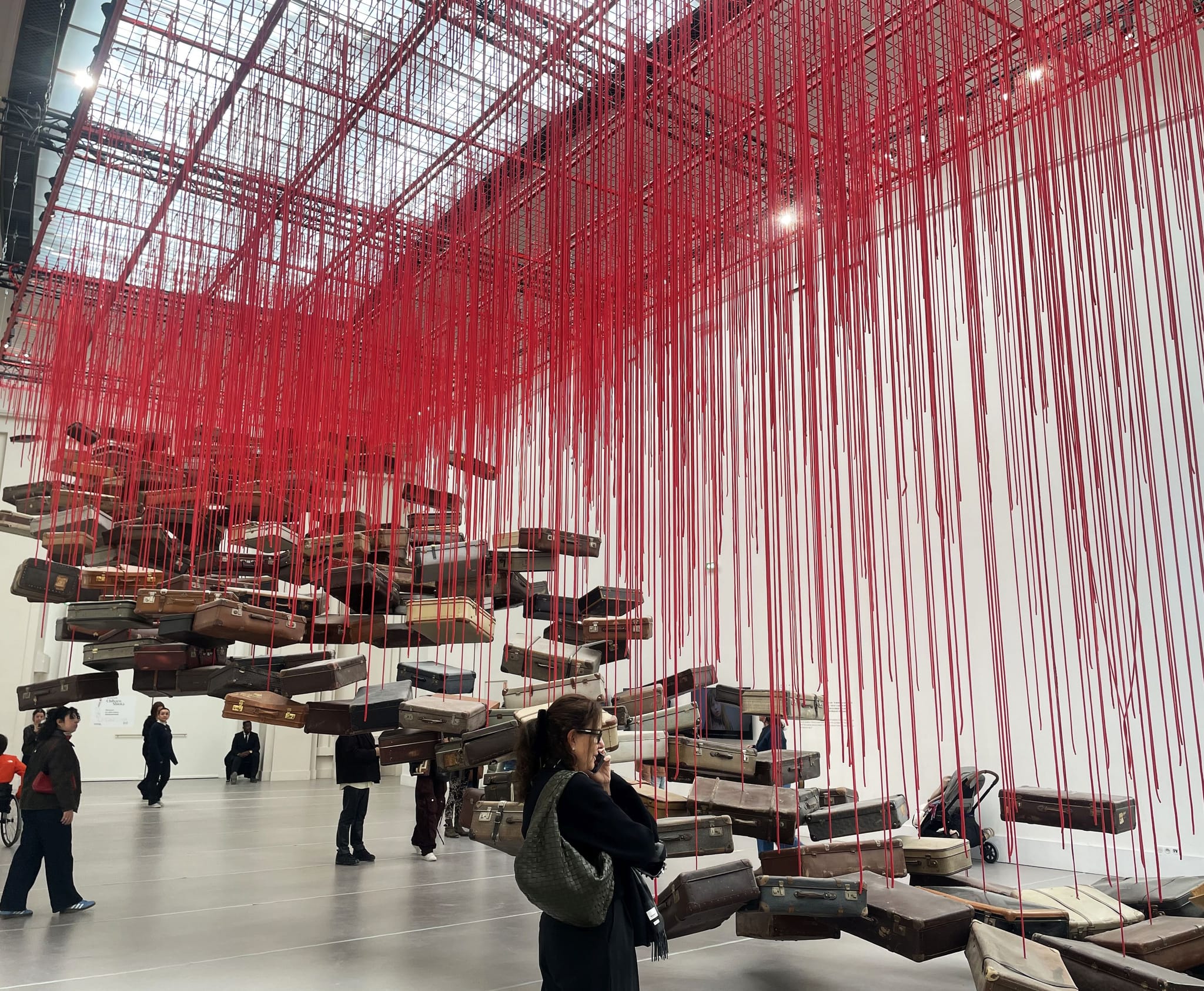 Koffer an roten Fäden, eine Installation von Chiharu Shiota im Grand Palais von Paris.