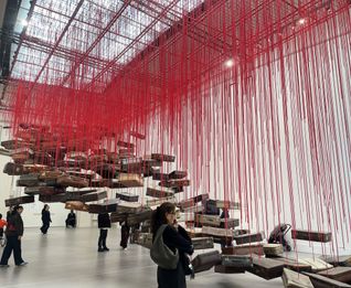 Koffer an roten Fäden, eine Installation von Chiharu Shiota im Grand Palais von Paris.