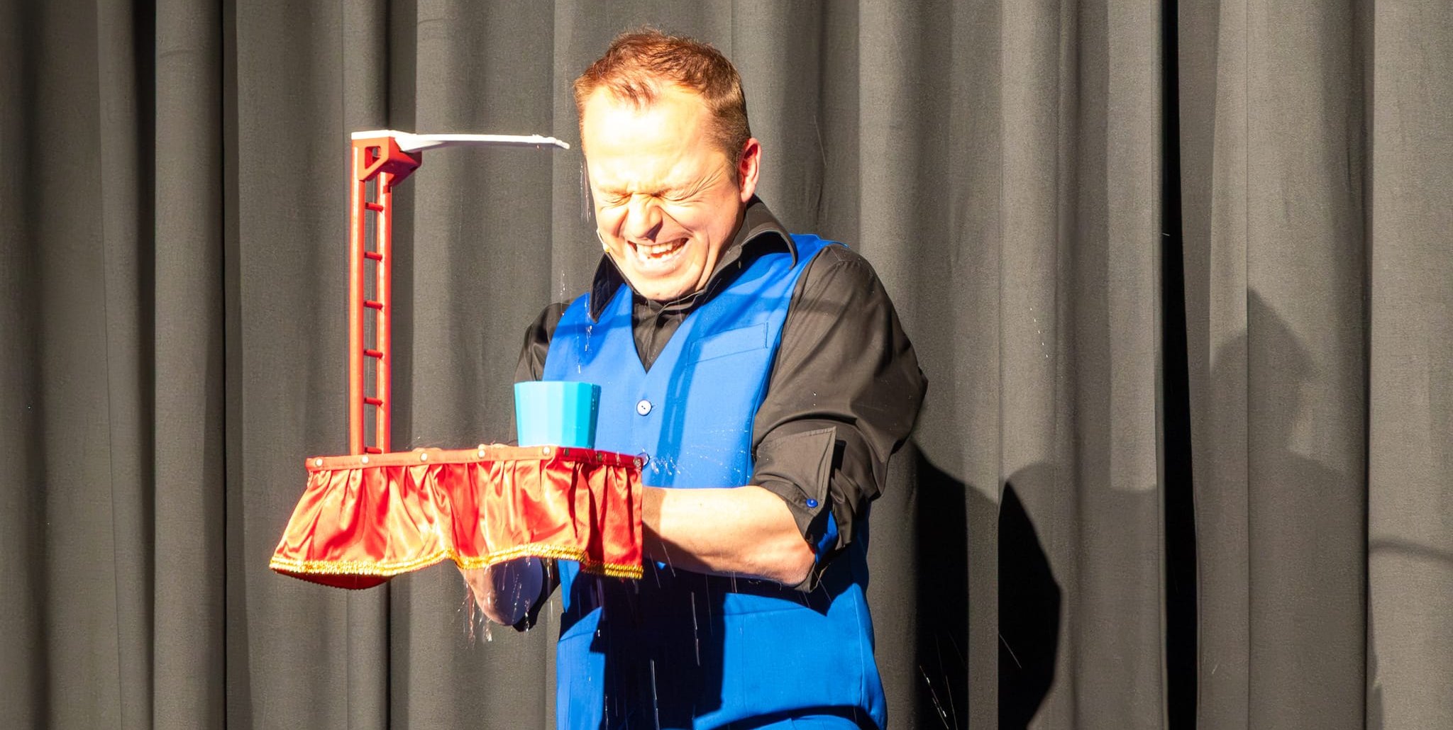 Stuntfloh Helmut macht Organisator beim Sprung ins Becken nass.