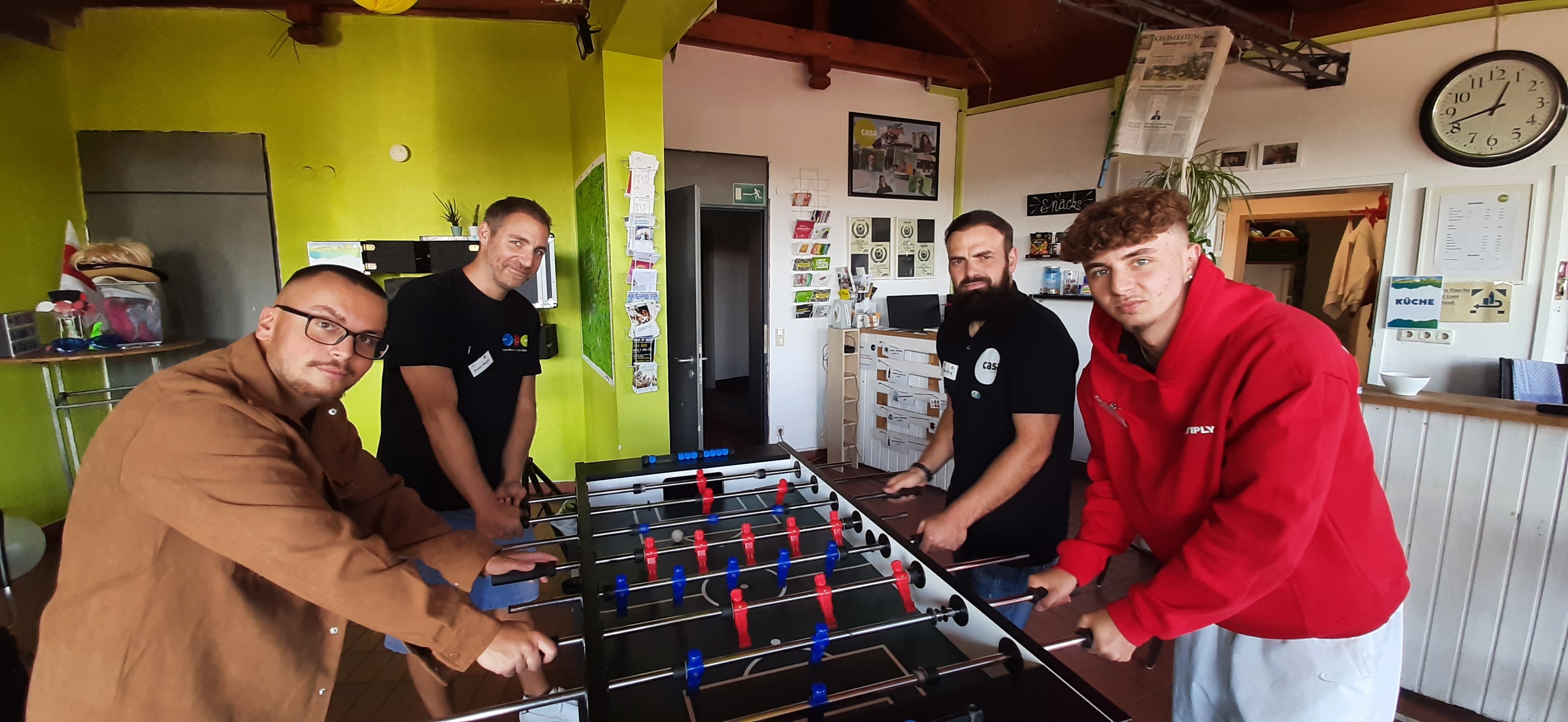 Zeit für ein ganz kurzes Tischkicker-Spiel ist auch am Tag der offenen Tür: Besucher Leo Silvamoita (vorne links), Casa-Nostra-Leiter Torsten Mayer (hinten links), Besucher Fynn Guse (vorne rechts) und Sozialarbeiter Besart Kuqi.
