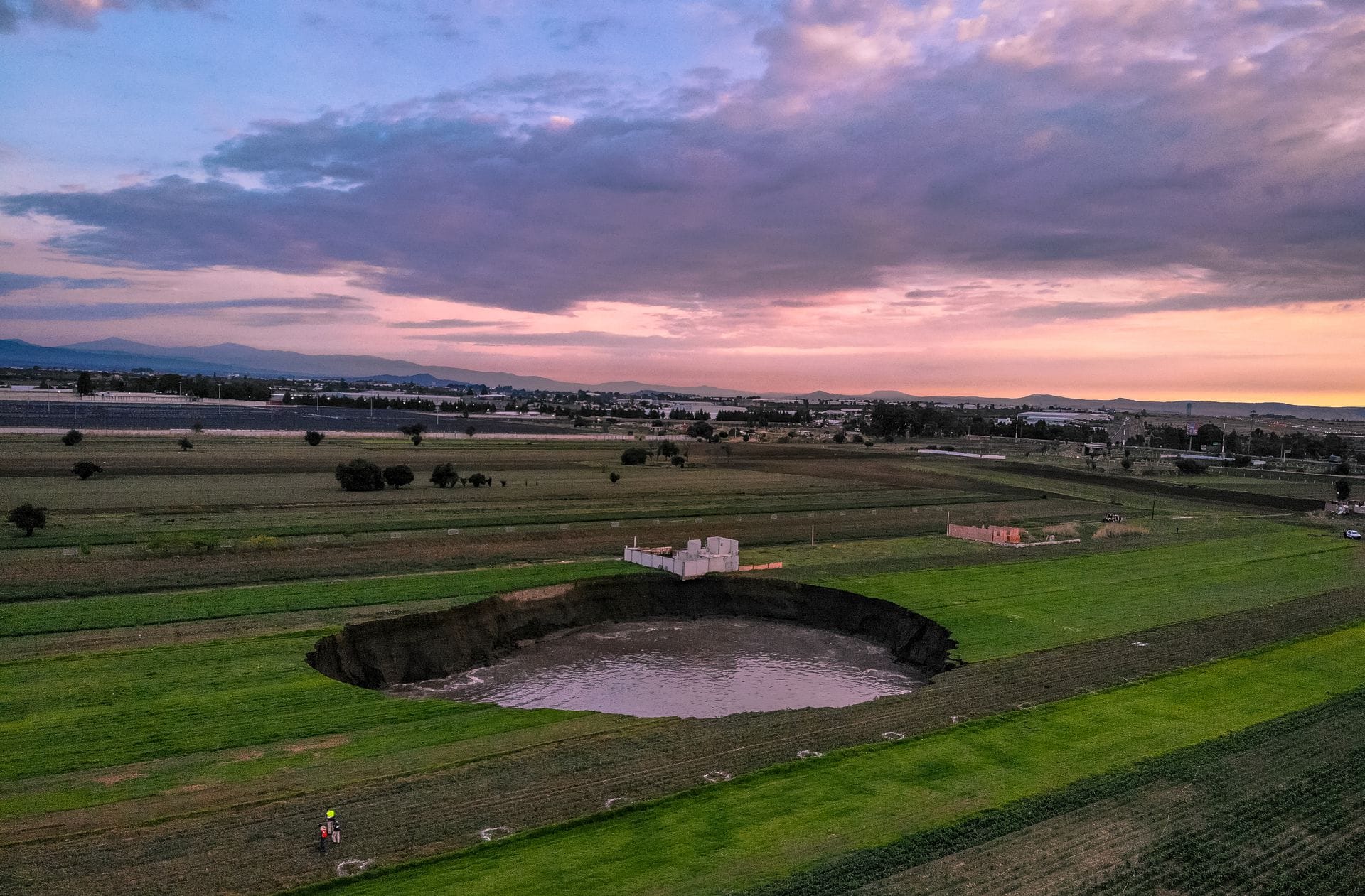 Auf einem Feld bei dem Ort Santa Maria Zacatepec ist der  mit Wasser gefüllte Krater zu sehen.