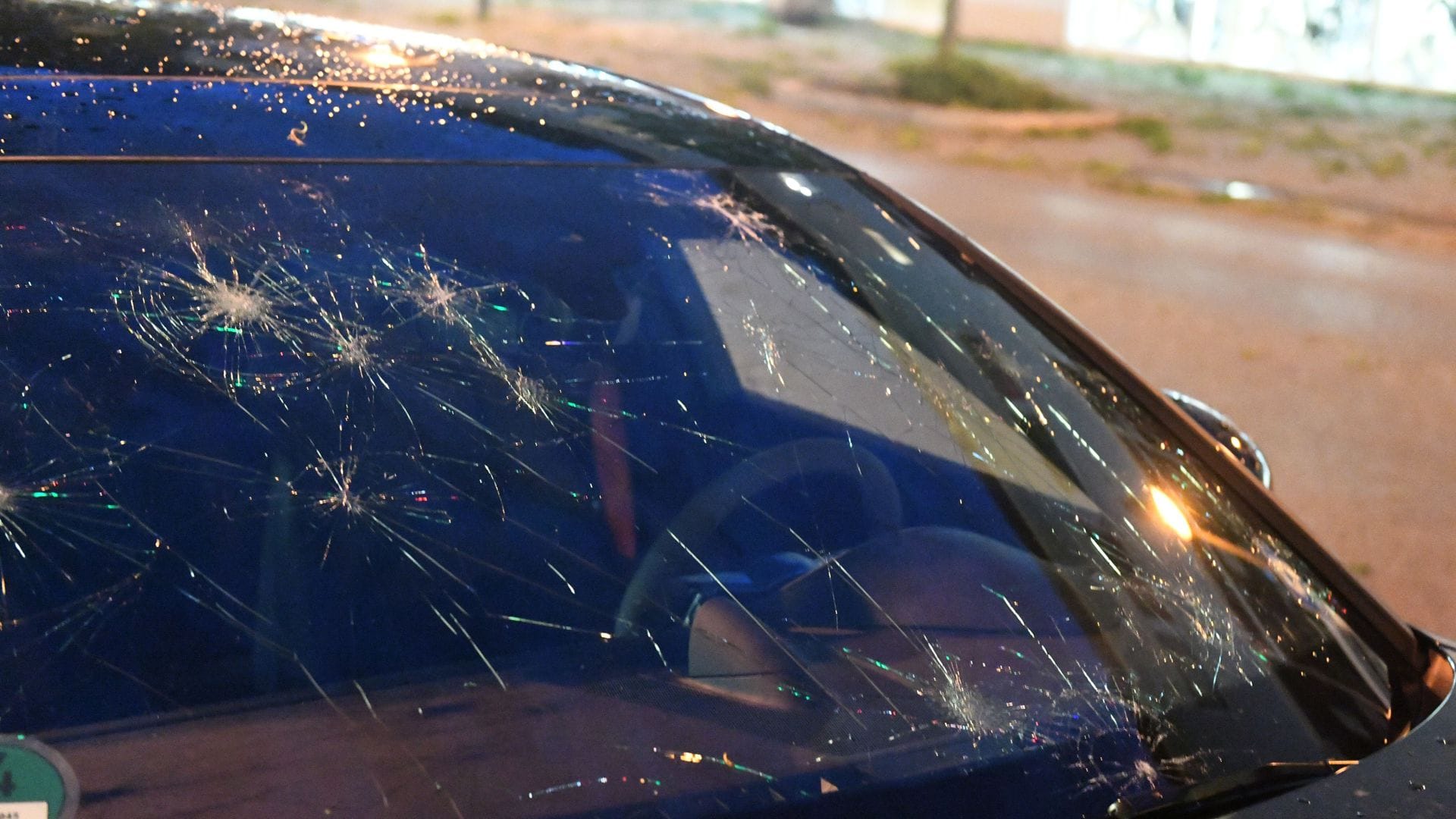 Eine durch Hagel bei einem Unwetter beschädigte Fensterscheibe eines Autos.