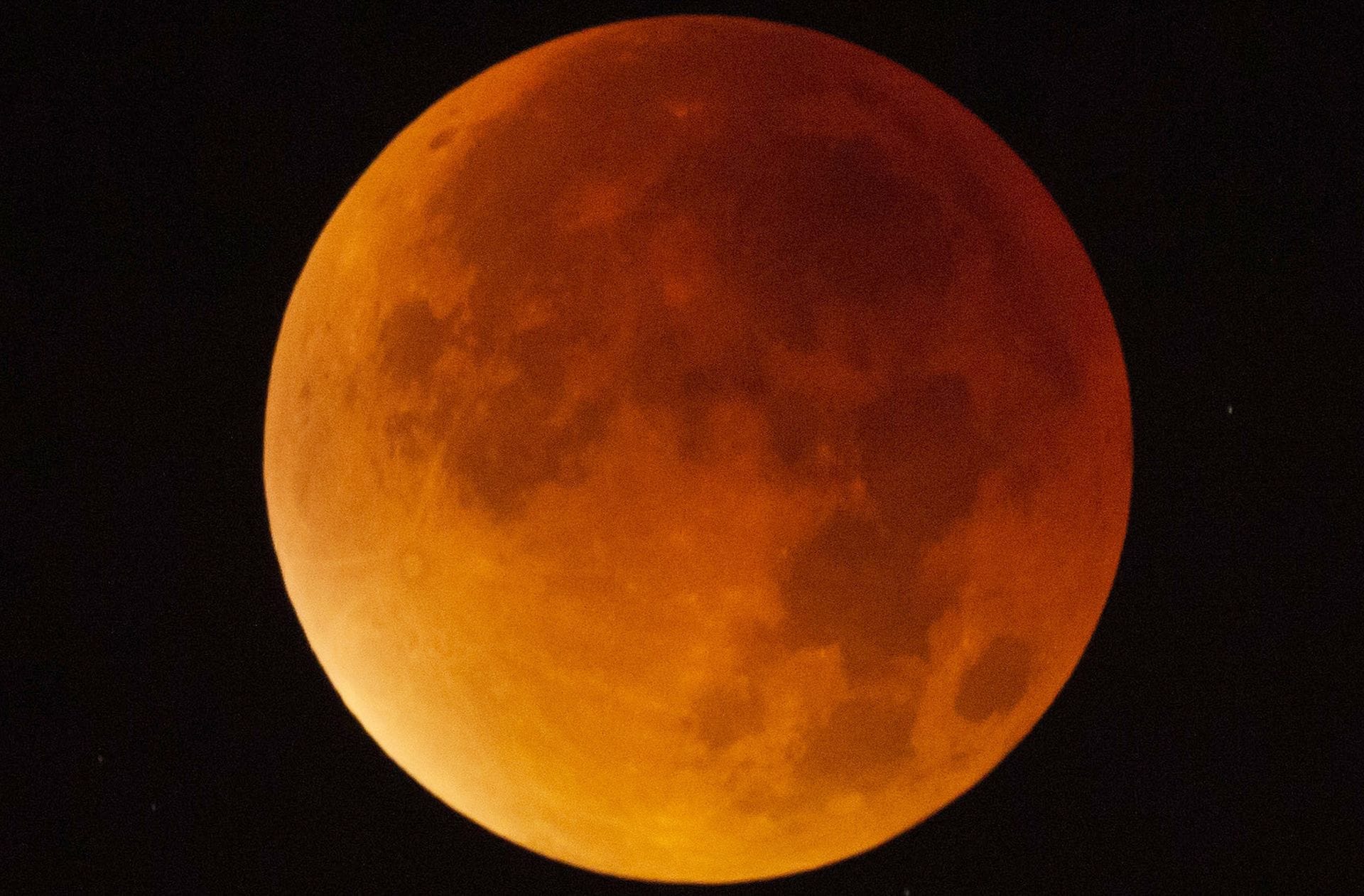 Der Mond erscheint am 21. Januar über Stuttgart während einer Mondfinsternis fast vollständig in einem rötlichen Farbton. Ursache des roten Schimmers sind die roten Anteile des Spektrums der Sonnenstrahlen, die durch die Erdatmosphäre in den Kernschatten der Erde abgelenkt werden.