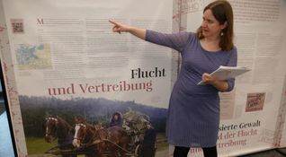 Patricia Erkenberg erläutert die Ausstellung im Haus der Donauschwaben.