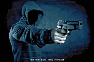 Der eine der beiden Täter zielte mit der Pistole durch die Glasscheibe der Tür.
