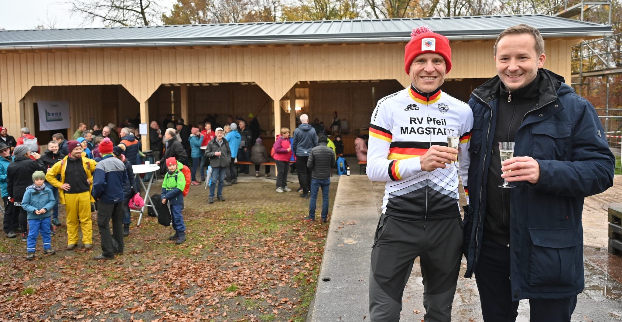 Bürgermeister Florian Glock (rechts) und Hannes Genze stoßen bei der Einweihungsfeier für die Blockhütte auf deren Wiederaufbau und auf Genzes Sieg beim Radrennen (die SZ/BZ berichtete) an.