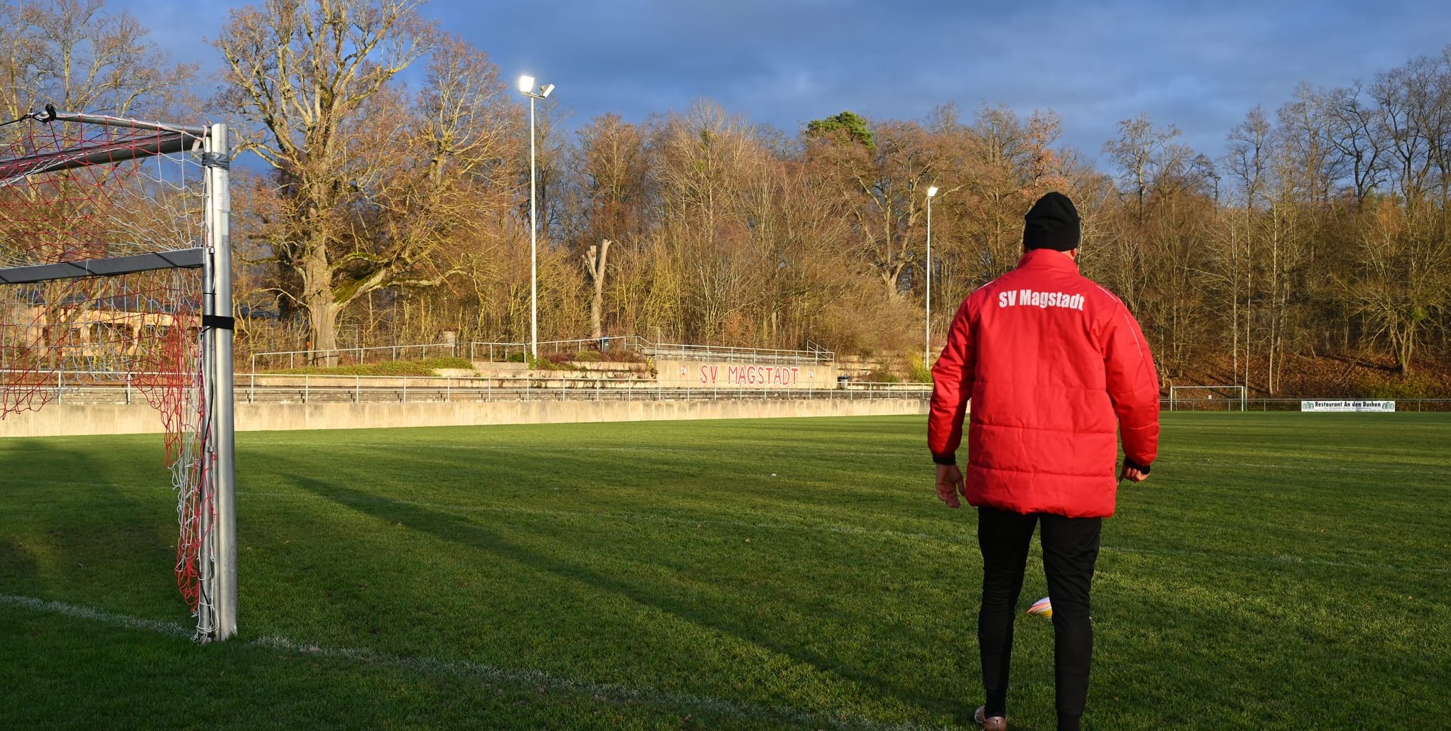 Die Flutlichter auf den Masten hinter der Tribüne des Magstadter Fußballstadions „An den Buchen“ bestrahlen teilweise nicht den Rasen, sondern die Äste der daneben stehenden Naturdenkmale. 	Bild: Reichert