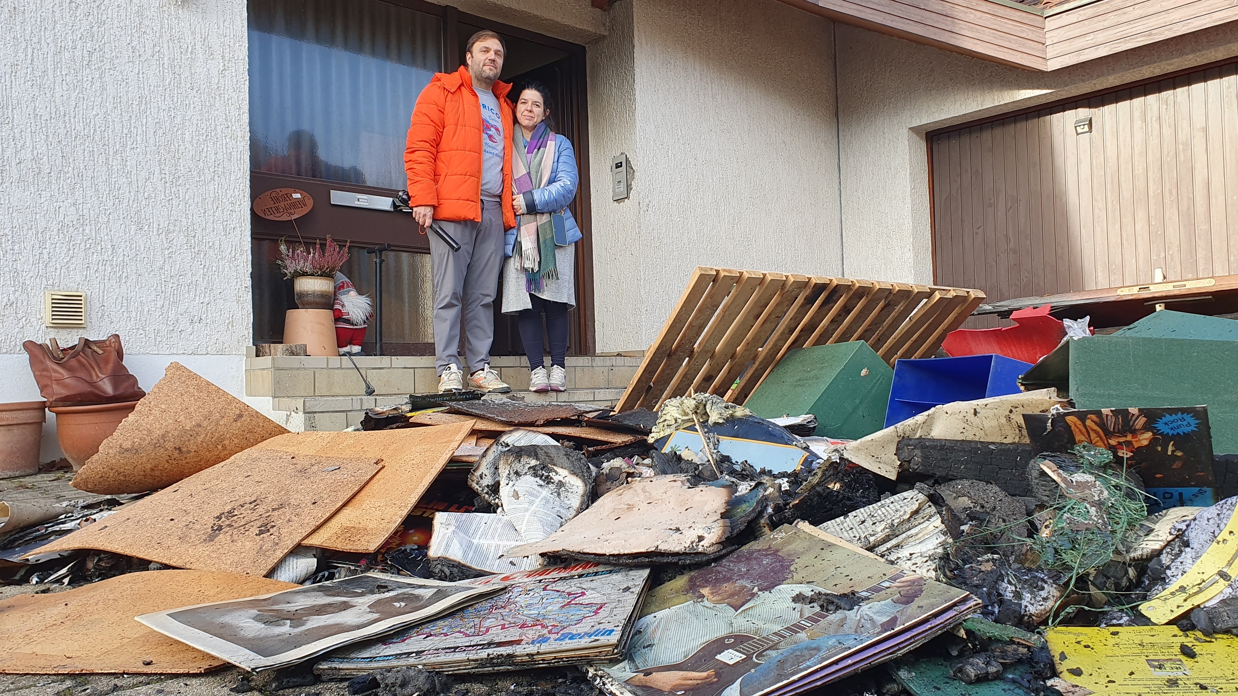 Alessandra und Julian Grumbach vor einem Teil des Brandguts, das die Feuerwehr aus dem Keller ihres Darmsheimer Hauses holte. Bild: Wegner/A