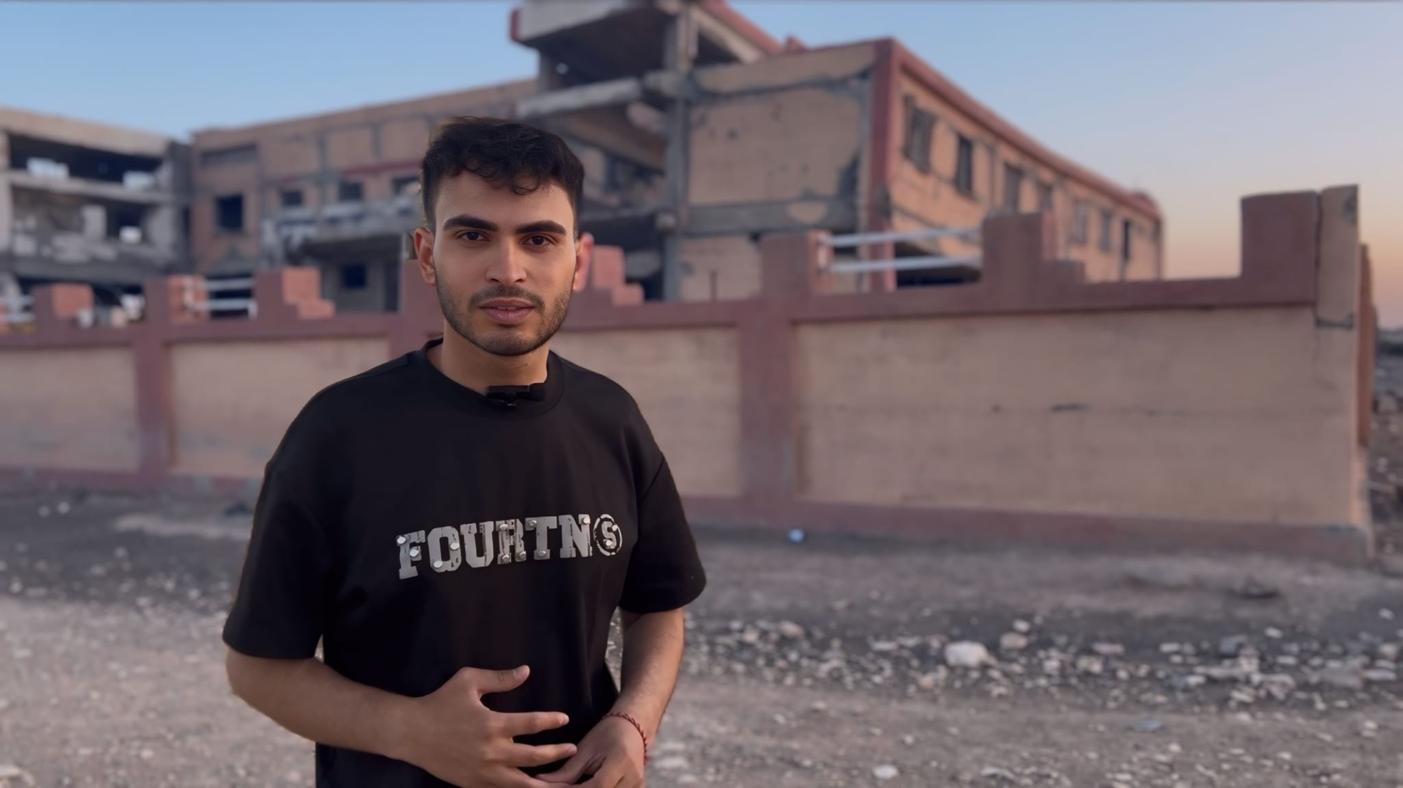 Saikshvly Ilyas beim Besuch in seiner Geburtsstadt Tel Benat vor einer zerstörten Schule.