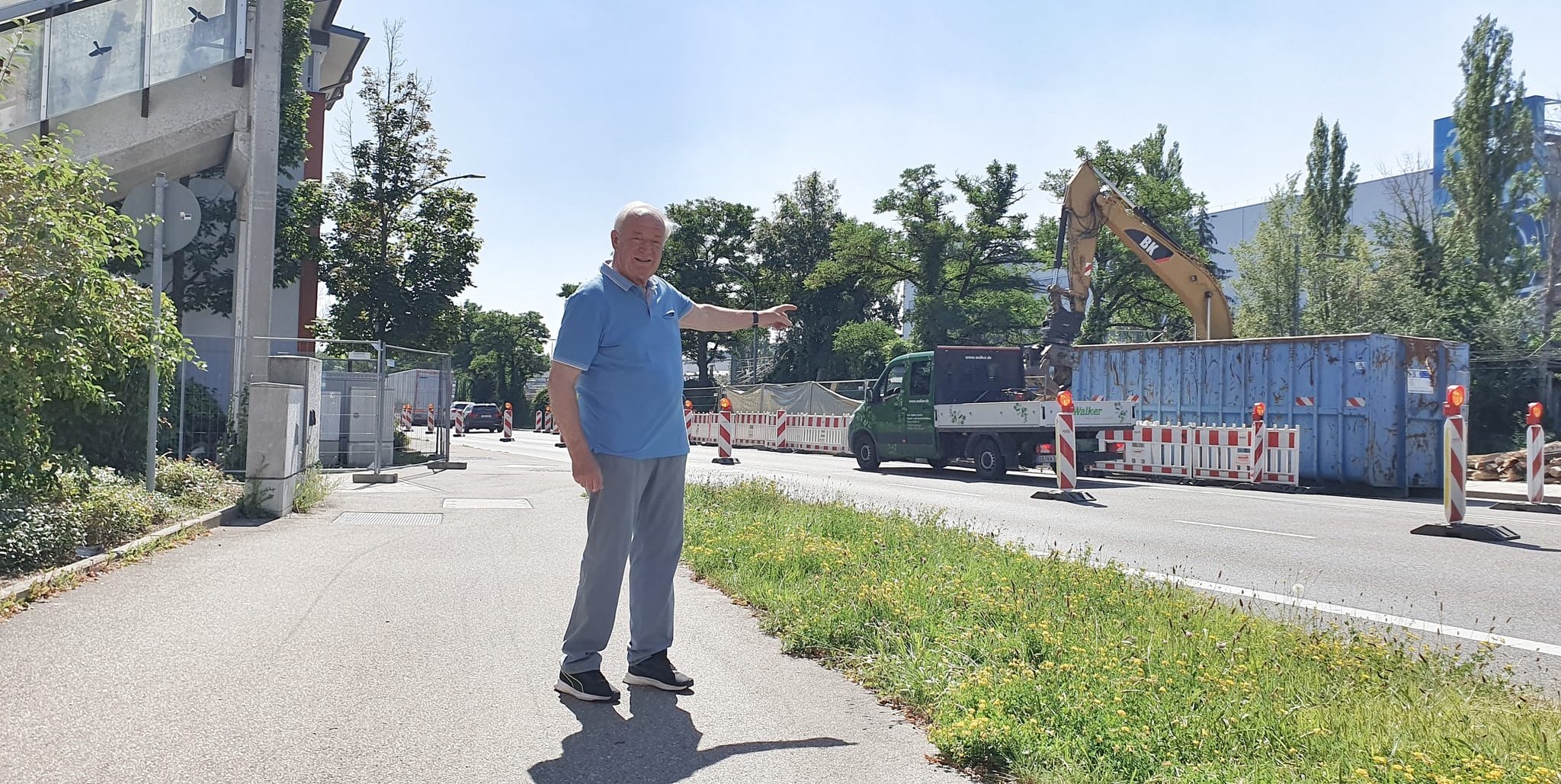 Dieter Gerold zeigt auf den Bagger, der auf der Fabrikseite nach dem Abriss aufräumt. Links im Bild sind noch die Reste des Stegs zu ernennen.