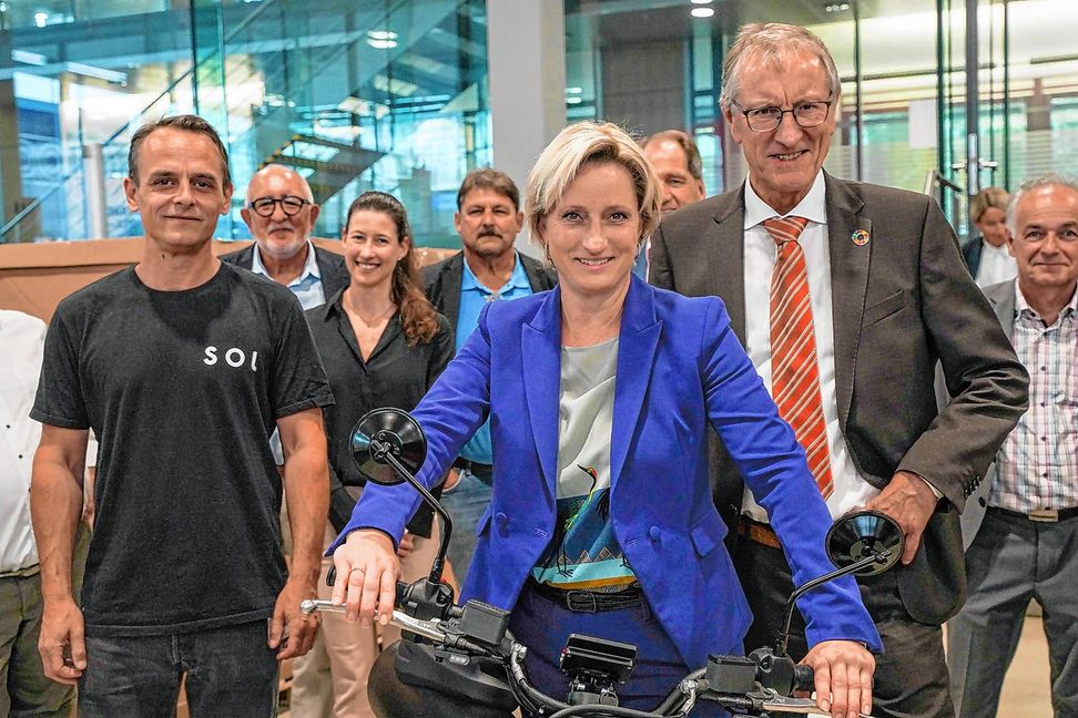 Das Lenkrad der Pocket Rocket fest im Griff: Die baden-württembergische Wirtschaftsministerin Dr. Hoffmeister-Kraut neben SOL-Motors-Geschäftsführer Manuel Messmer (vorne links) und Landrat Roland Bernhard.