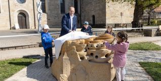 Oberbürgermeister Dr. Bernd Vöhringer mit Kindern der Kita Klostergarten beim Enthüllen des Murmelsteins.
