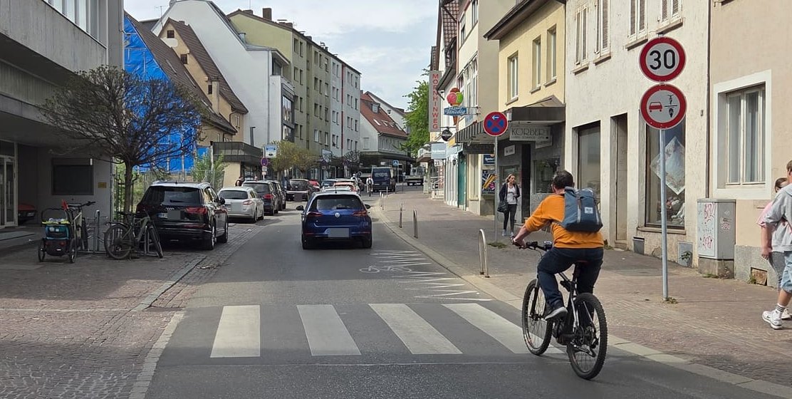 Der Radfahrer darf hier nicht überholt werden. Aber darf er die Straße verlassen und auf den Gehweg ausweichen?