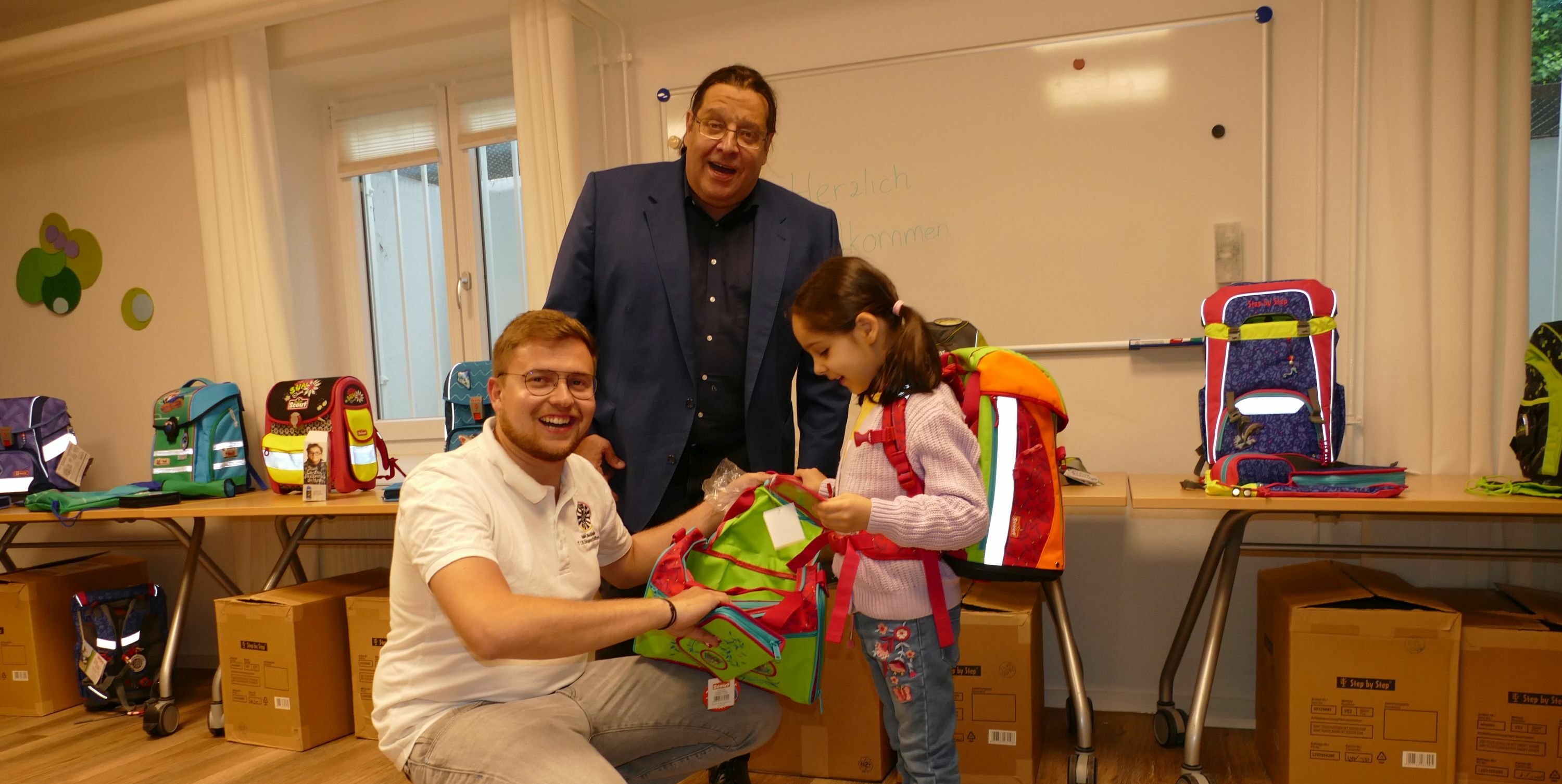 Robin Zellhöfer, Projektleiter bei Round Table 129, und Tom Bredow, Bezirksgeschäftsführer des Evangelische Diakonieverbandes in Leonberg, mit einem glücklichen Mädchen.
