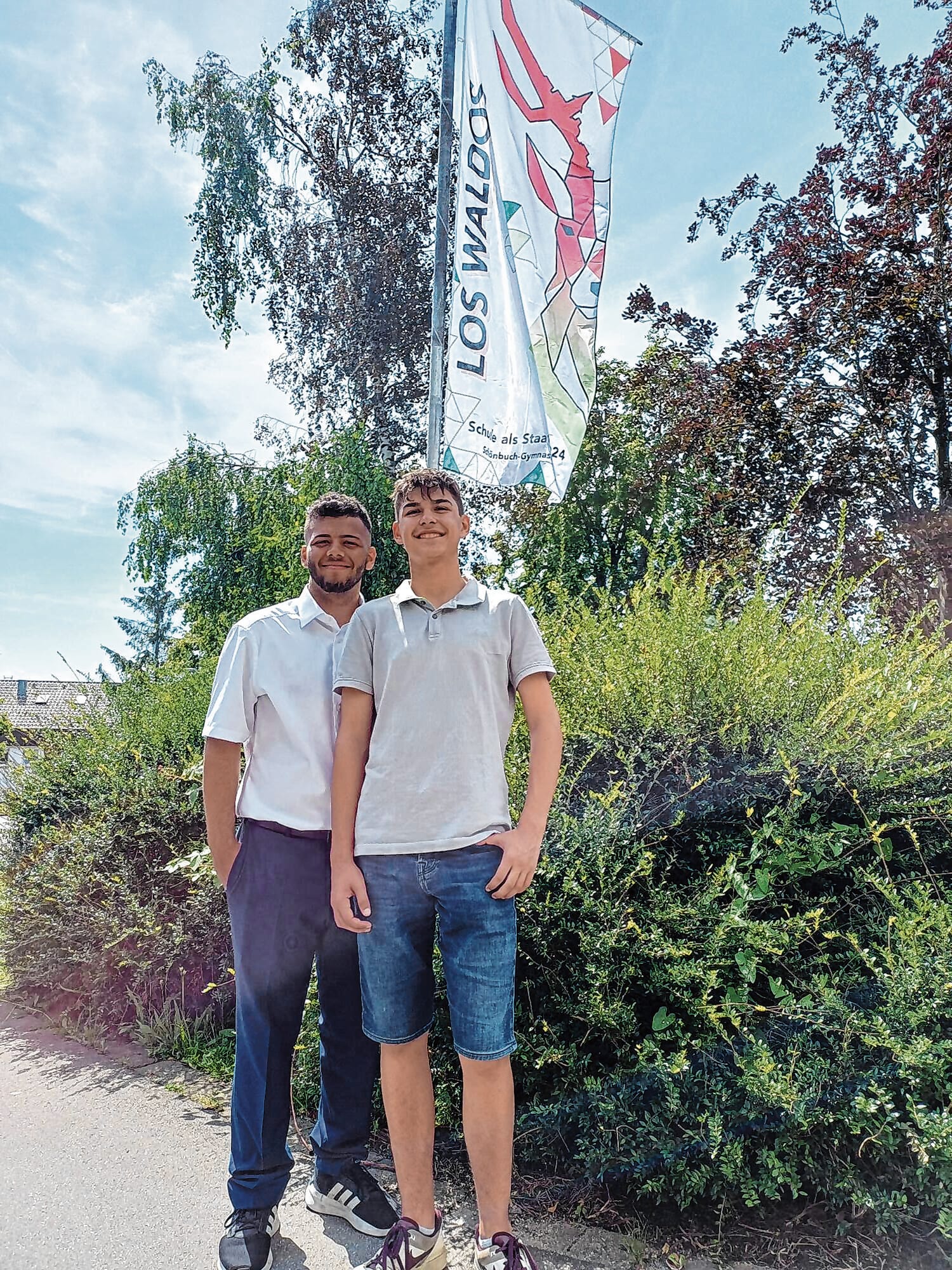 Marcel Yassine (links) und Tobias Kunz vor der „Los Waldos“- Flagge am Schönbuch-Gymnasium.